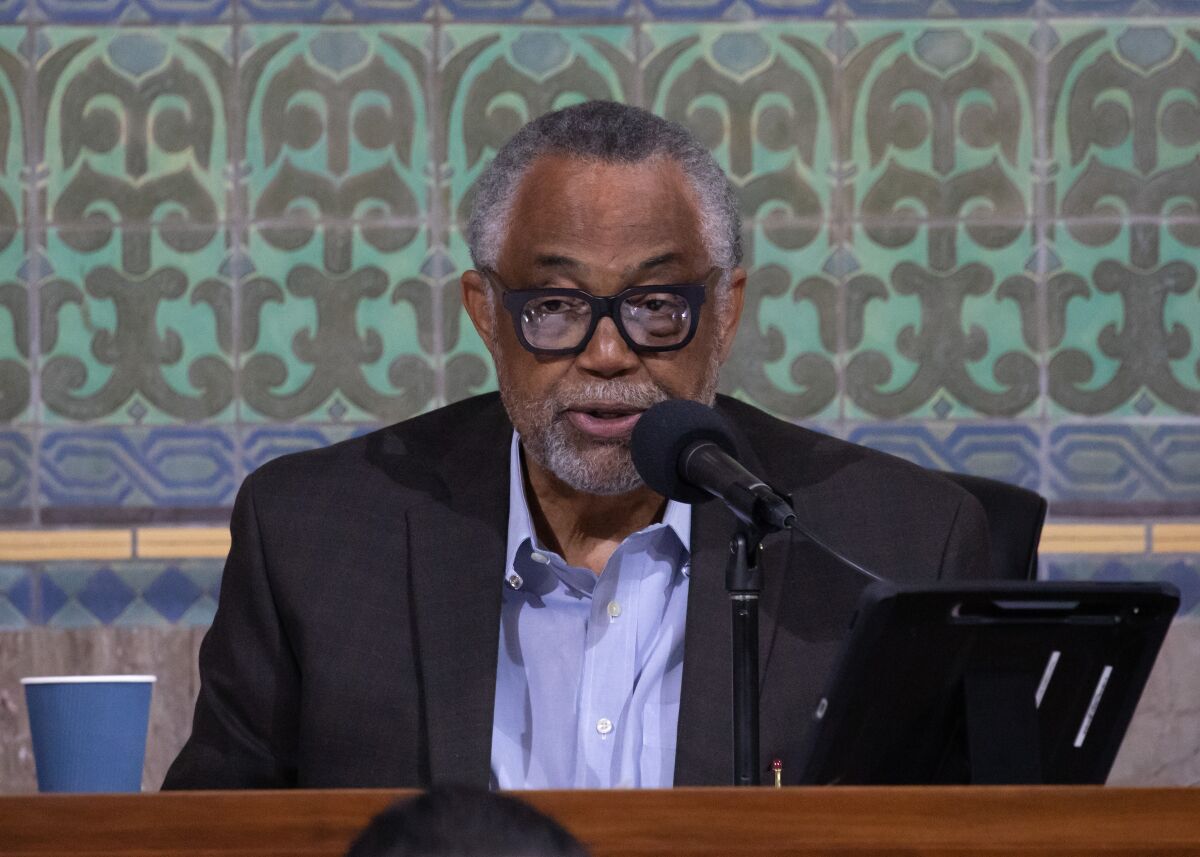 Los Angeles City Councilman Curren Price sits as a table and speaks into a microphone