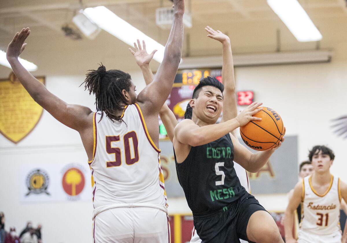 Costa Mesa's Christian Dasca goes up for a shot against Estancia's Lewis Tate during the first Battle for the Bell game.