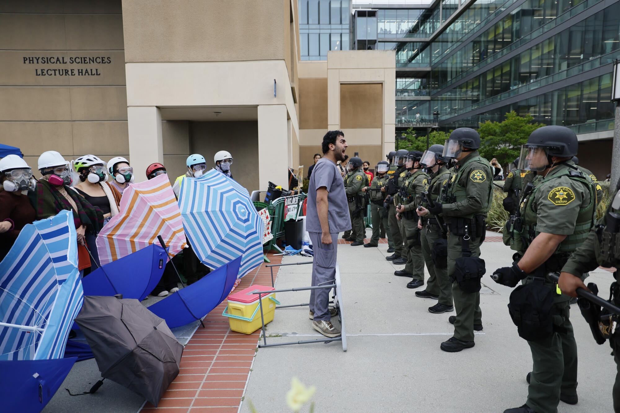 A pro-Palestinian demonstrator confront law enforcement at UCI.