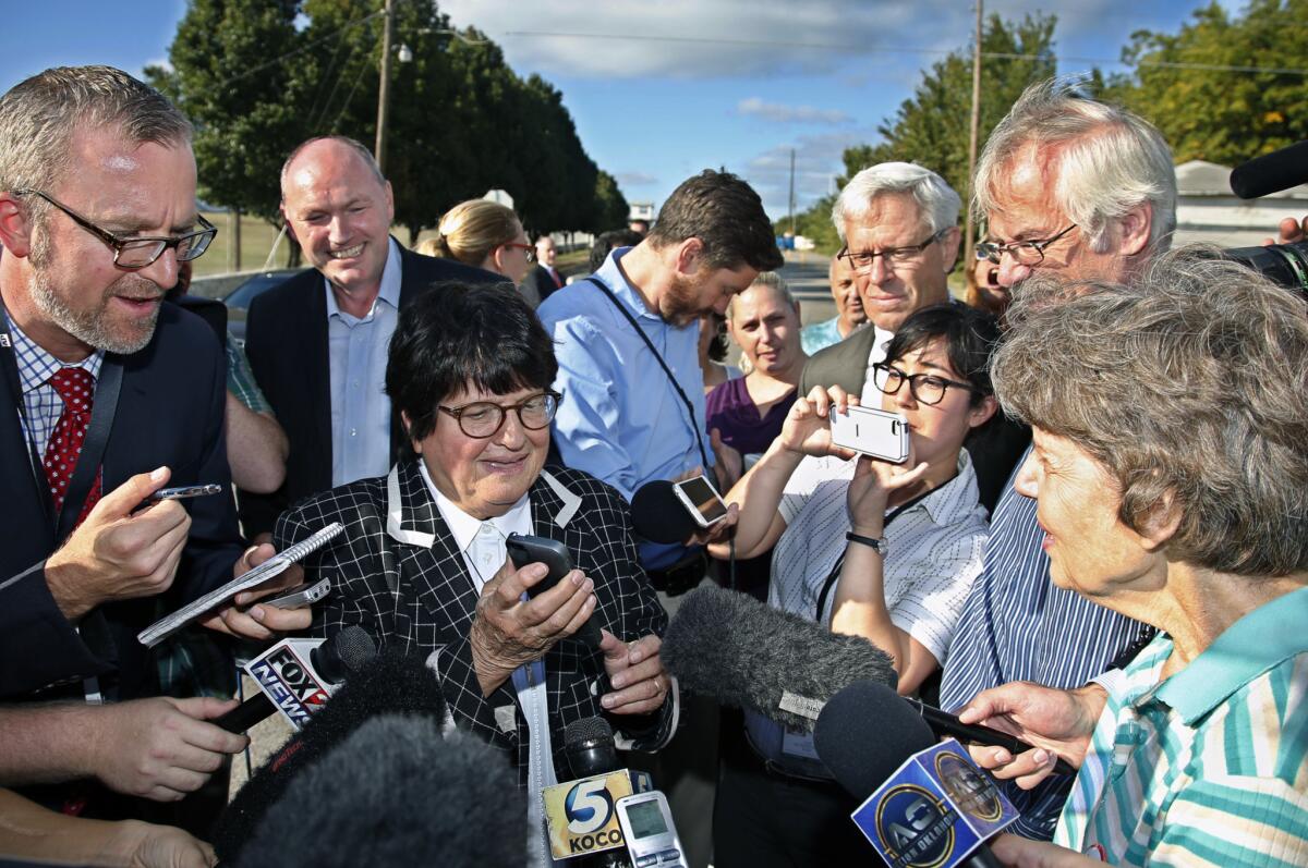 Death penalty opponent Sister Helen Prejean, center, tries to put death row inmate Richard Glossip on a speaker phone outside the Oklahoma State Penitentiary in McAlester after his execution was delayed on Sept. 30 because the state discovered it had the wrong drug for its lethal-injection protocol.
