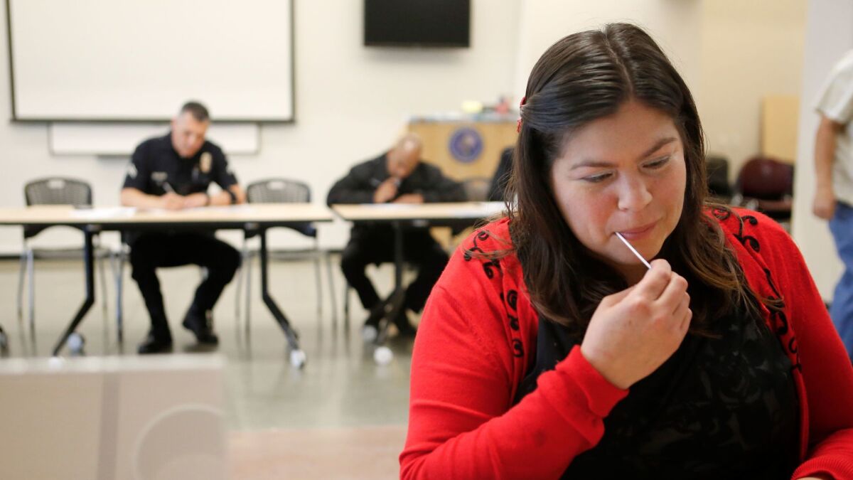 Jacqueline Chilin swabs cells from her cheek that will be tested to determine if she is a match for LAPD Officer Matthew Medina, who needs a bone marrow transplant. (Christian K. Lee / Los Angeles Times)