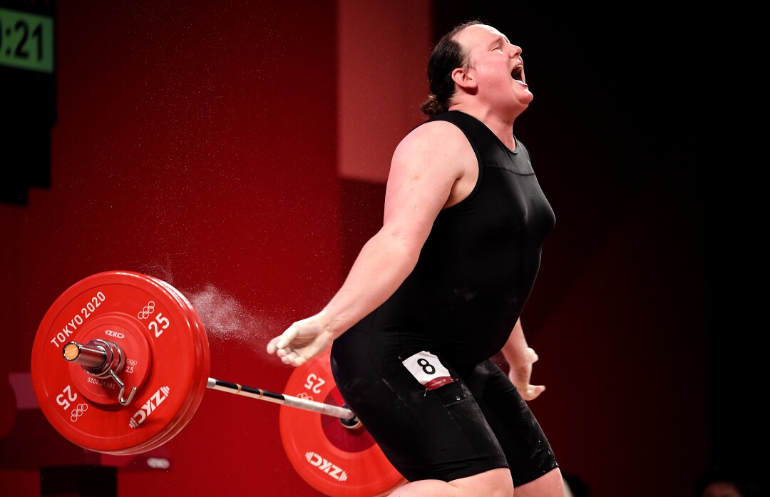 A woman opens her mouth and drops her weights behind her