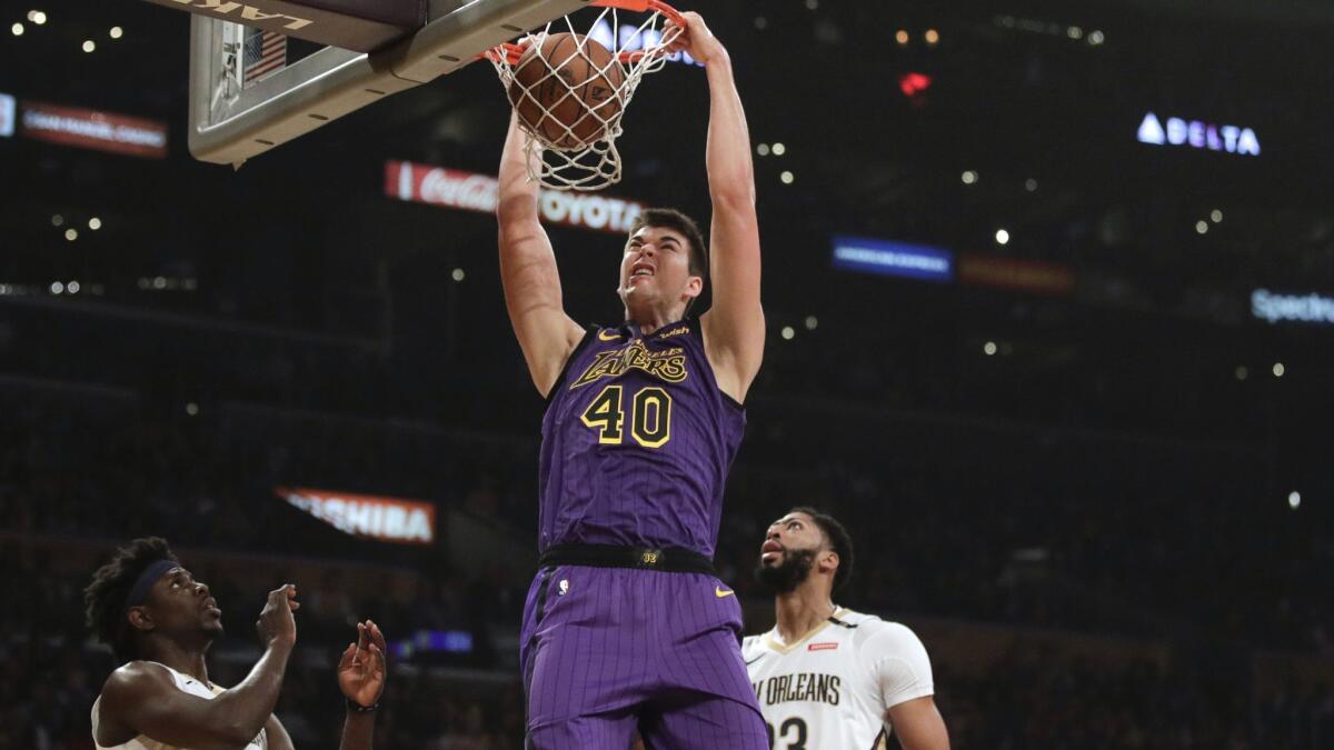 Lakers' Ivica Zubac, center, dunks as New Orleans Pelicans' Jrue Holiday, left, and Anthony Davis watch during the first half.