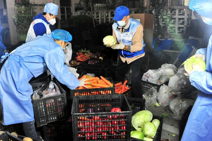 SHANGHAI, CHINA - APRIL 07: Volunteers arrange food supplies at a gated community after Shanghai imposed a citywide lockdown to halt the spread of COVID-19 epidemic on April 7, 2022 in Shanghai, China. (Photo by Yang Jianzheng/VCG via Getty Images)