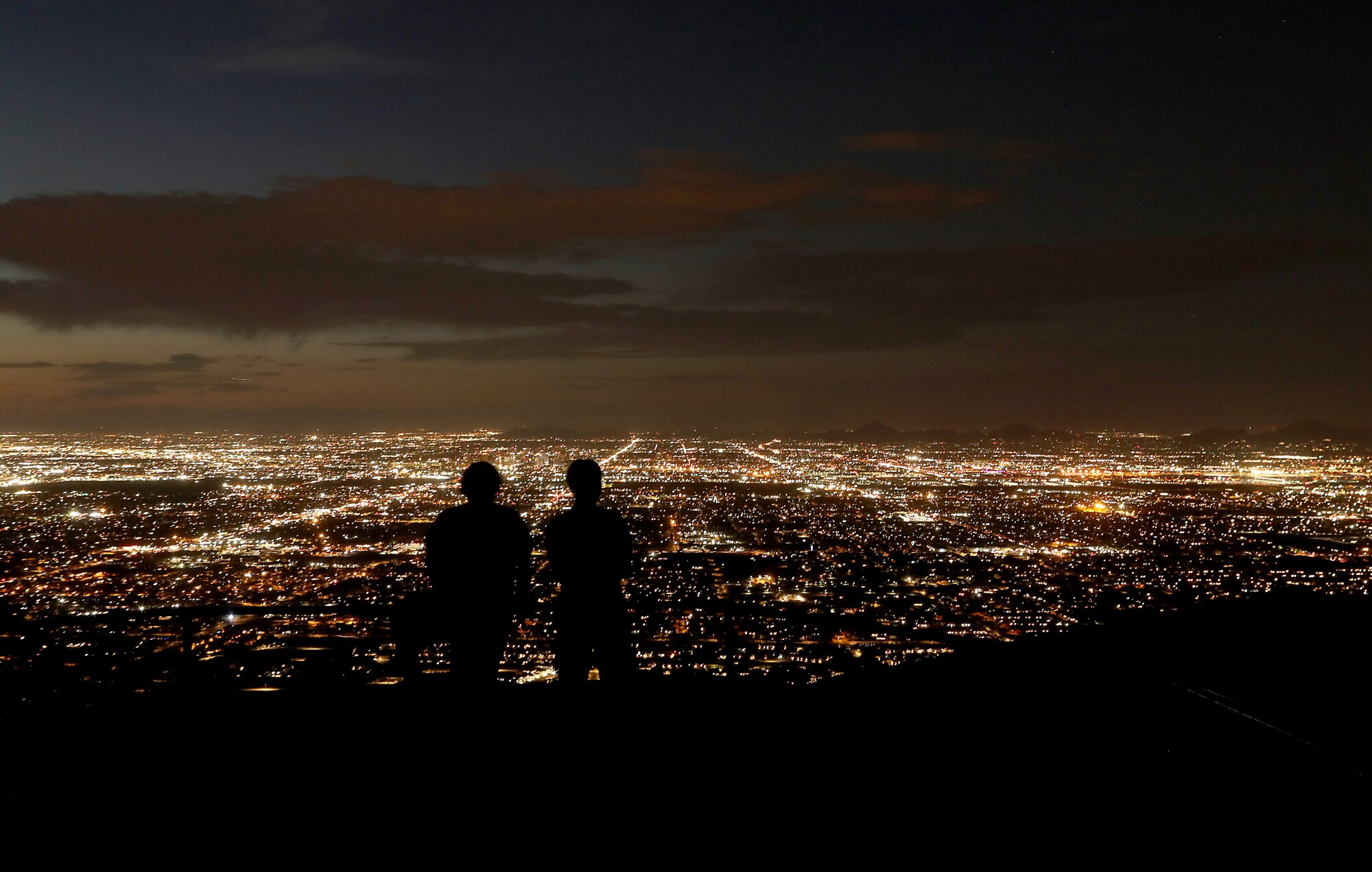 Visitors to Dobbins Lookout see the lights of Phoenix in the Valley of the Sun below. 
