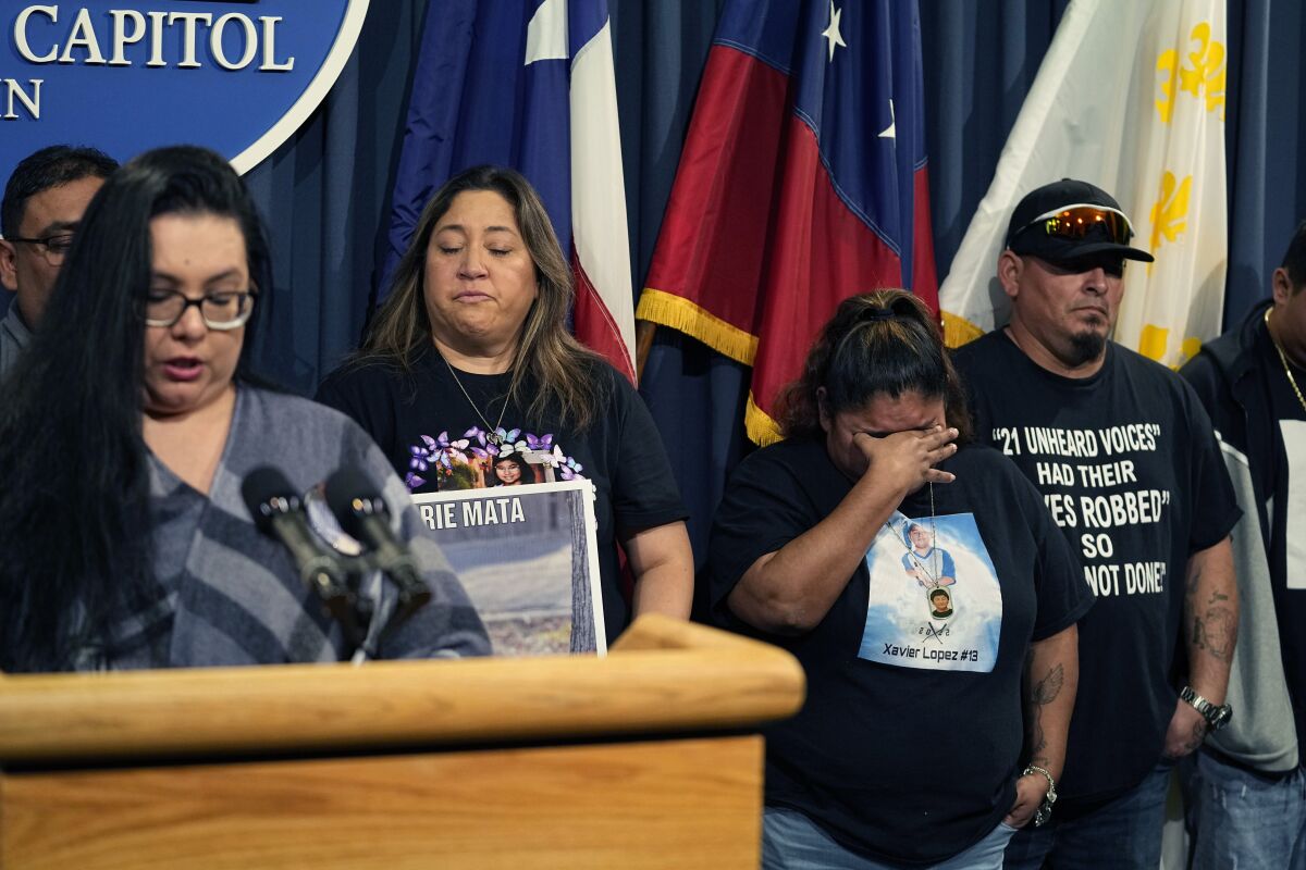 Felicia Martinez, mother of Xavier Lopez who was killed by a gunman at Robb Elementary School in Uvalde, Texas, center tries to hold back tears as she and other surviving family members attend a news conference at the Texas Capitol with Texas State Sen. Roland Gutierrez, in Austin, Texas, Tuesday, Jan. 24, 2023. Gutierrez says he is filing legislation in the wake of Texas' rising gun violence. (AP Photo/Eric Gay)