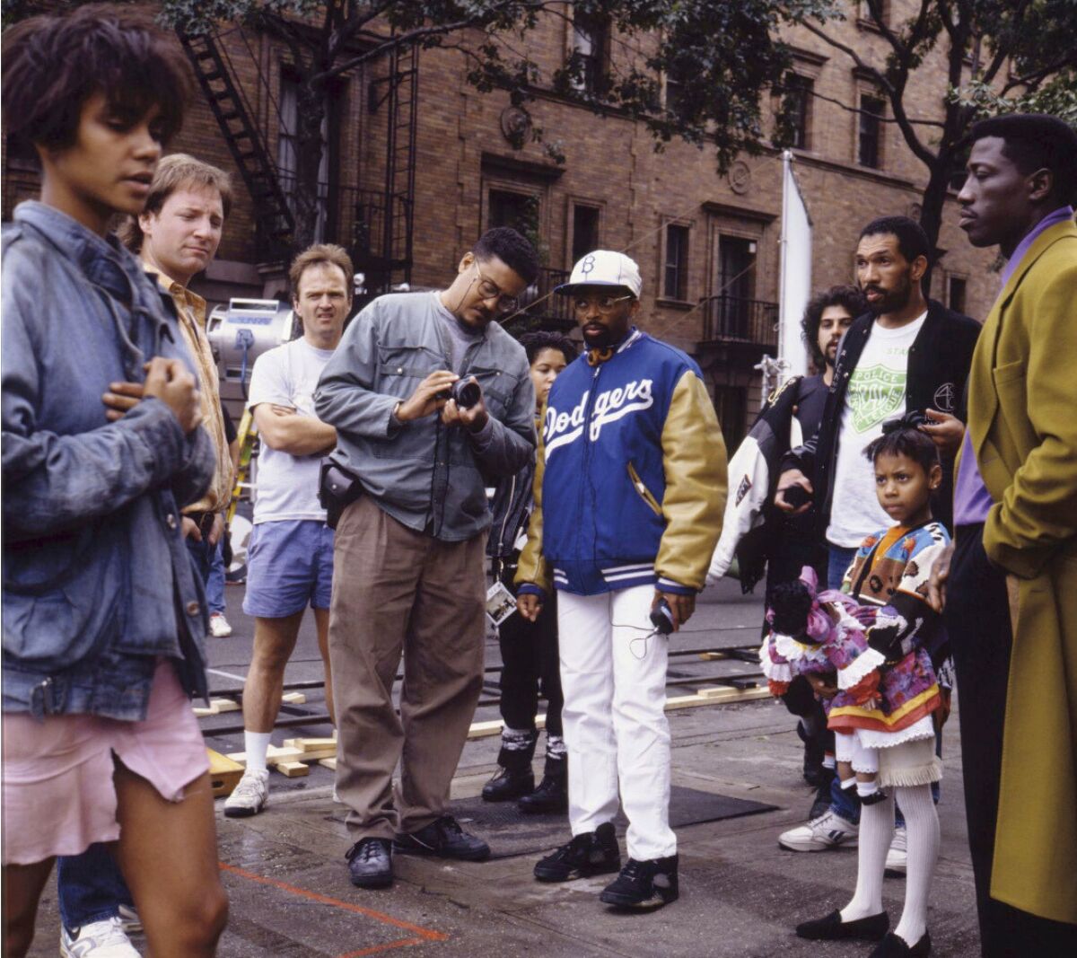 Filmmaker Spike Lee, center right, appears with his brother David Lee, center left, with castmembers, including Halle Berry, left, and Wesley Snipes, right, on the set of the 1991 film, "Jungle Fever." A new photography book spanning Spike's career brings together images shot by David, from the making of "Do the Right Thing" to "Da 5 Bloods." It's an intimate look at the filmmaker, as seen through his brother's lens. (Universal Pictures via AP)