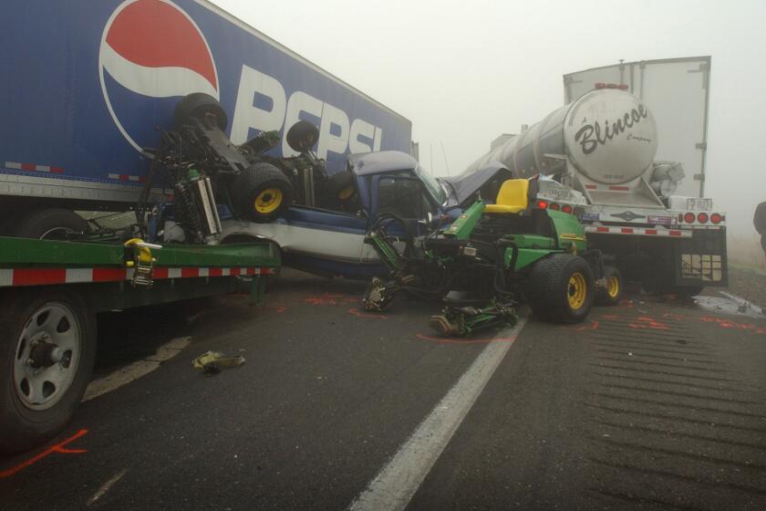 The driver of one of six semi trucks involved in a nine-car pileup walks by the wreckage at the scene on Highway 99 south of Merced, Calif. Wednesday, Nov. 20, 2002. Extremely dense fog was blamed on this and at least two other collisions on the highway, which runs north to south from Bakersfield to Sacramento. Only one injury was reported in the incident. (AP Photo/The Merced Sun-Star, Dave Getzschman)