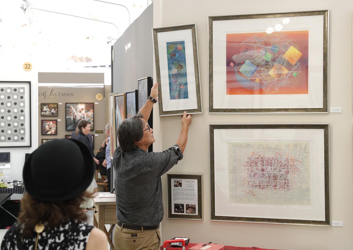 Printmaker Noriho Uriu watches her assistant hang a print at the Festival of Arts opening reception in Laguna Beach.