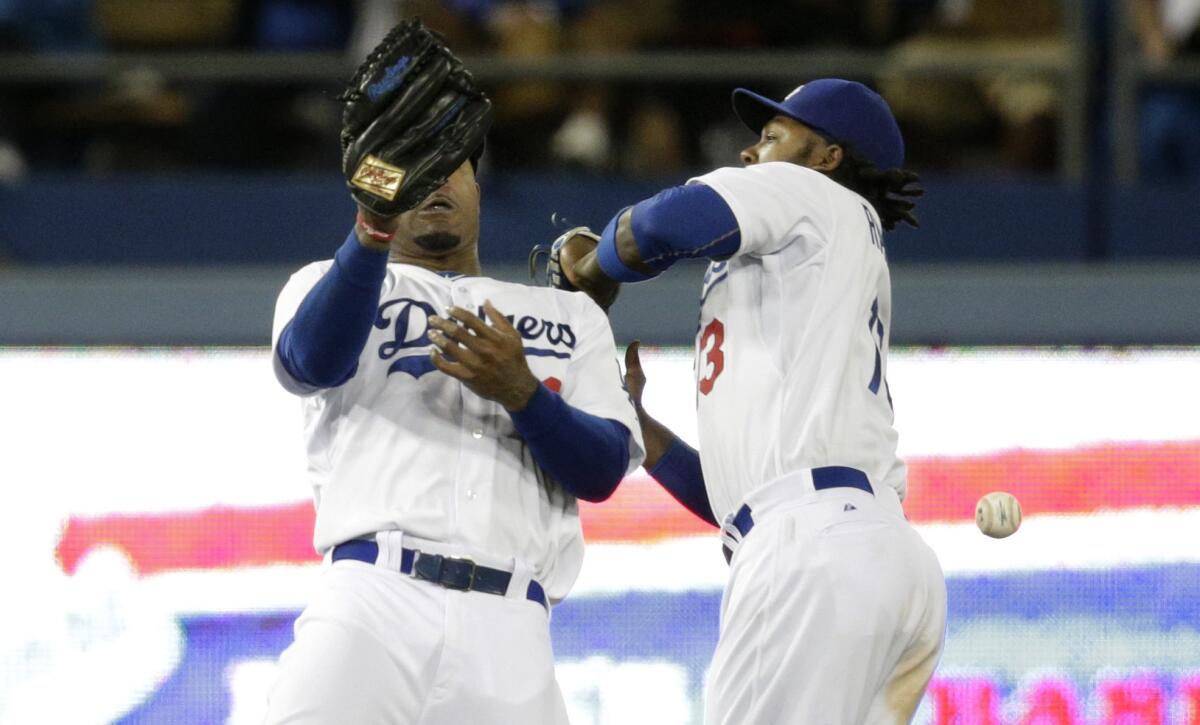 Dodgers teammates Hanley Ramirez, left, and Carl Crawford can't make a catch on a ball hit by Philadelphia's Carlos Ruiz during the 10th inning of the Dodgers' 3-2 loss in 10 innings Tuesday.