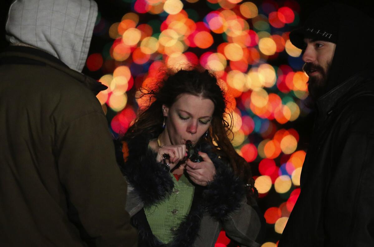 A woman in Seattle lights her pipe as supporters celebrate the legalization of marijuana in Washington state.