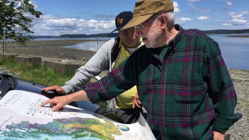 David McCloskey, right, points out a feature of his map of Cascadia to a vistor at Nisqually Reach, on the southern shore of Puget Sound.