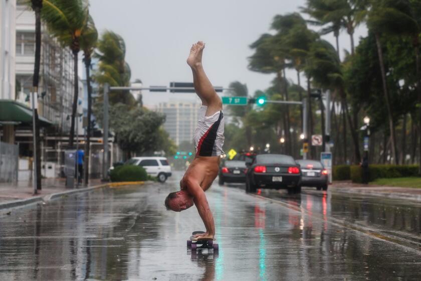 MIAMI BEACH, FLA. -- SATURDAY, SEPTEMBER 9, 2017: Adam Todd, does a handstand while skateboarding down Ocean Drive in Miami Beach, Fla., on Sept. 9, 2017. (Marcus Yam / Los Angeles Times)