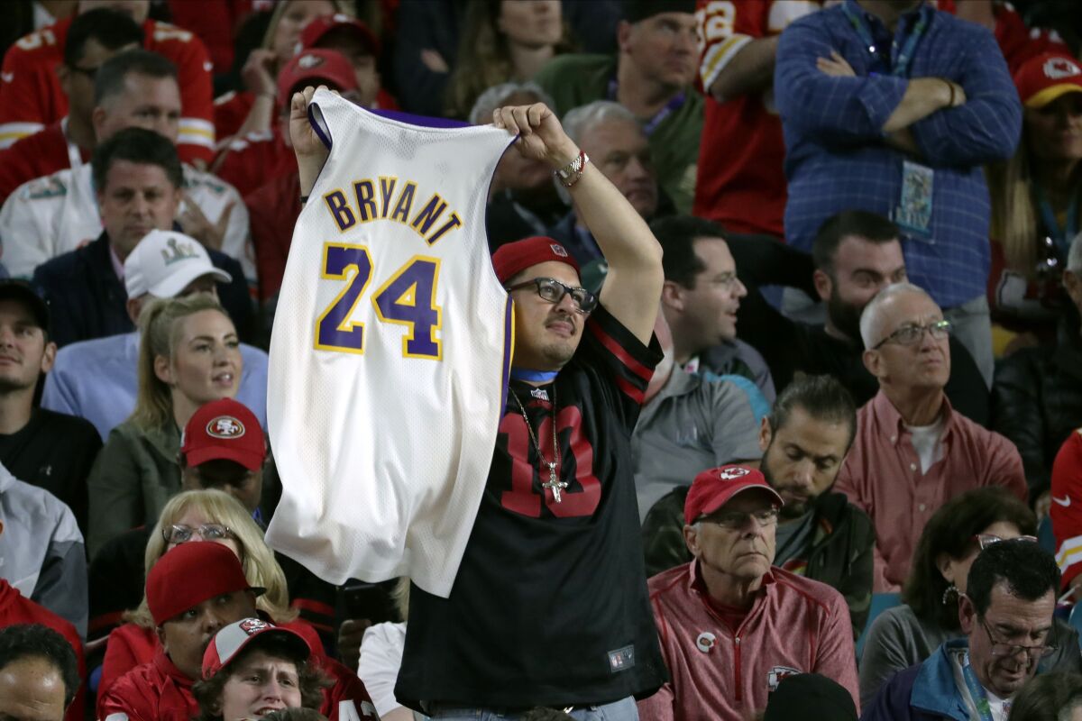 A fan in the stands holds a jersey honoring late NBA basketball legend Kobe Bryant during the second half of the NFL Super Bowl 54 football game between the San Francisco 49ers and the Kansas City Chiefs Sunday, Feb. 2, 2020, in Miami Gardens, Fla. (AP Photo/Matt York)