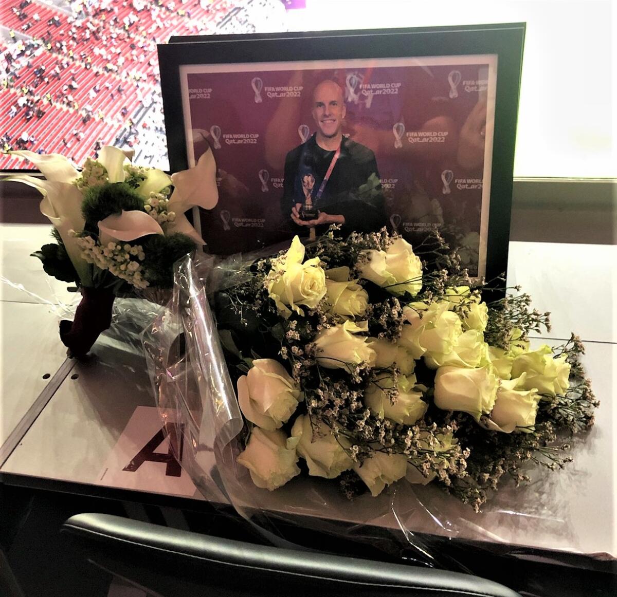 FIFA set up flowers and a photo honoring journalist Grant Wahl at his assigned World Cup seat.
