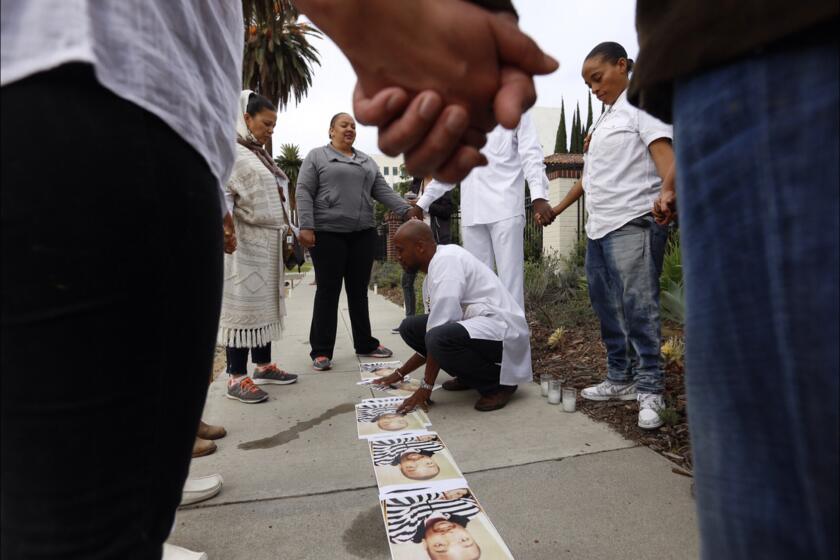 Protesters join hands outside Mayor Eric Garcetti's home early Sunday morning, calling for the mayor to take action over last summer's fatal shooting of Ezell Ford.