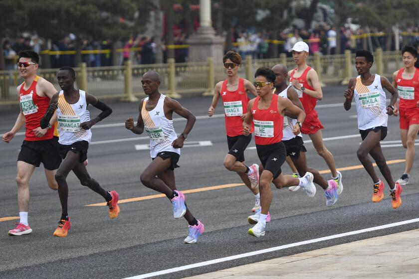 In this photo released by Xinhua News Agency, He Jie, the men's marathon record holder in China, wearing number 1, runs alongside African competitors during the Bejjing Half-Marathon 2024 in Beijing on Sunday, April 14, 2024. Organizers are investigating the half-marathon race in Beijing after video from the race showing three African runners appearing to let the Chinese runner ahead of them right as they are about to cross the finish line sparked public speculation that the race was rigged. (Ju Huanzong/Xinhua via AP)