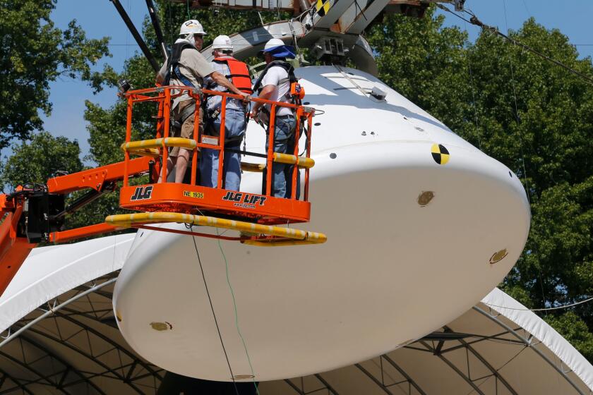 Workers prepare a full-scale replica of NASA's Orion spacecraft for a simulated ocean splashdown test at NASA's Langley Research Center in Hampton, Va.