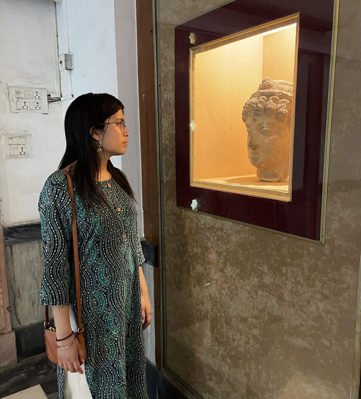 Nirja Trivedi looking at an ancient statue of the Buddah while visiting the National Museum in New Delhi, India.
