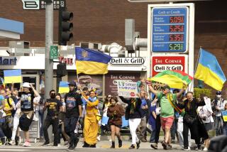 WESTWOOD, CA - FEBRUARY 26, 2022 - - Hundreds of Ukrainian Americans and others march past a gas station featuring high prices for gas during a rally to denounce Russia's invasion of Ukraine along Santa Monica Blvd. in Westwood on February 26, 2022. (Genaro Molina / Los Angeles Times)