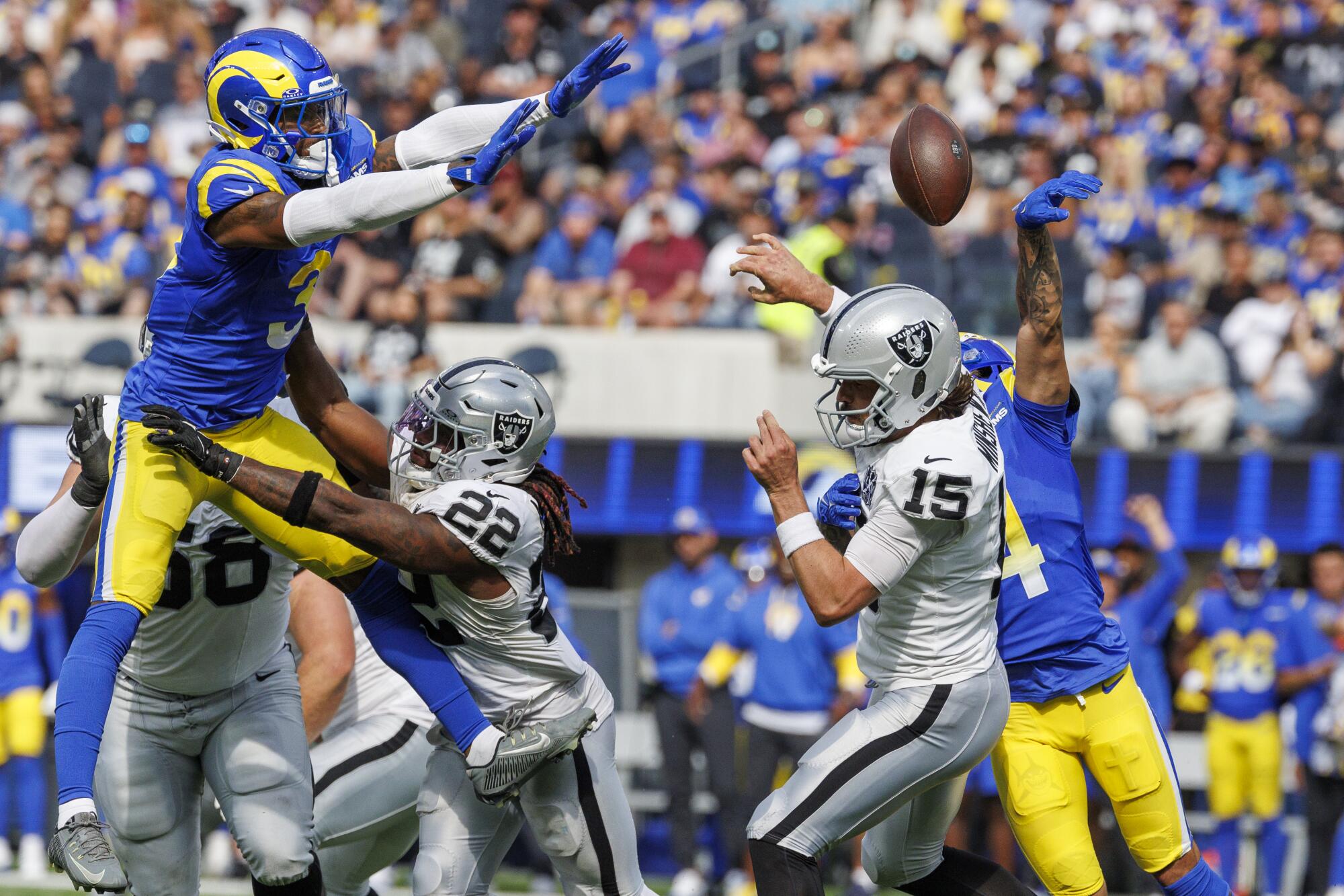 Rams cornerback Cobie Durant, right, forces Las Vegas Raiders quarterback Gardner Minshew to fumble the ball.