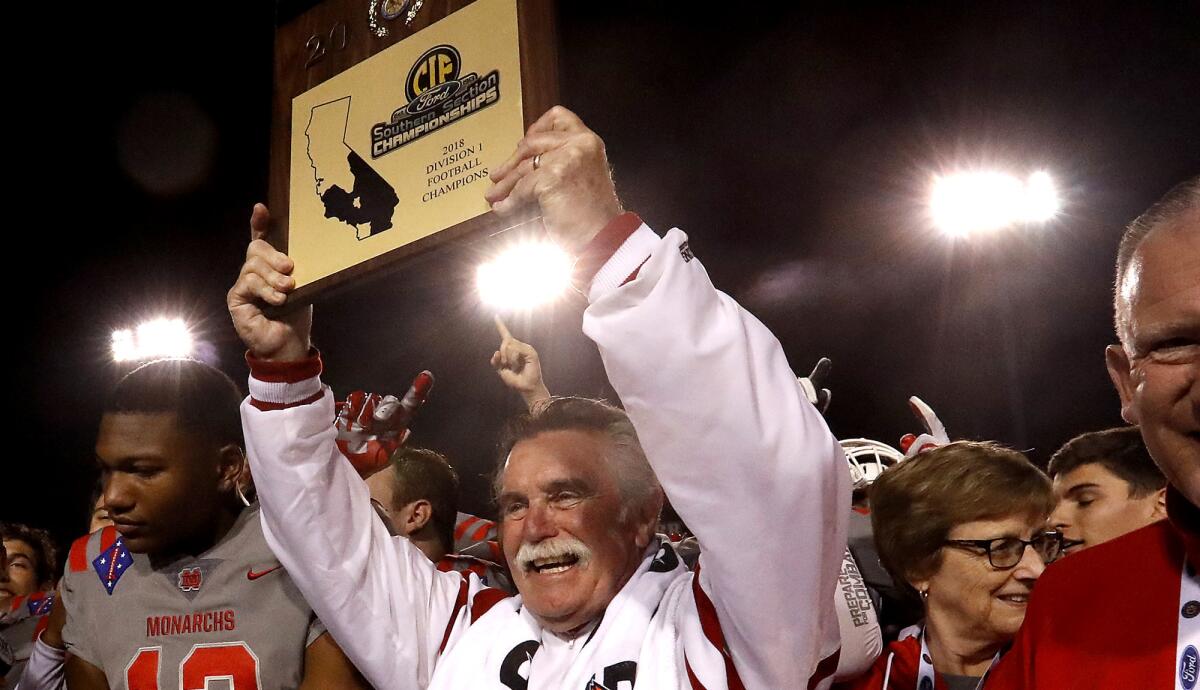 Mater Dei coach Bruce Rollinson holds up the Southern Section championship trophy after the Monarchs defeated St. John Bosco in the Division 1 championship game.