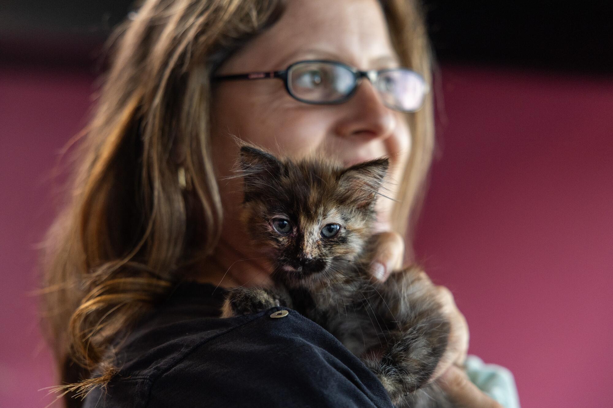 La mujer tiene un gato en el hombro.