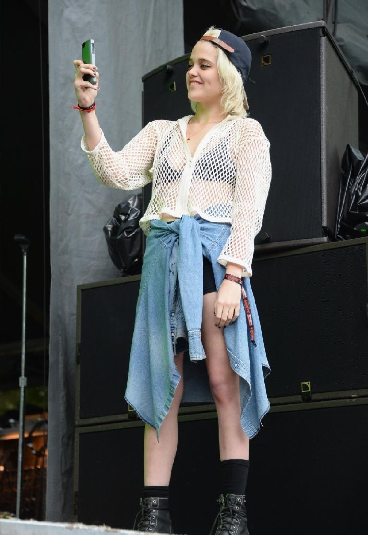 Grunge style star Sky Ferreira takes in DIIV's performance at Lollapalooza 2013 at Grant Park in Chicago.