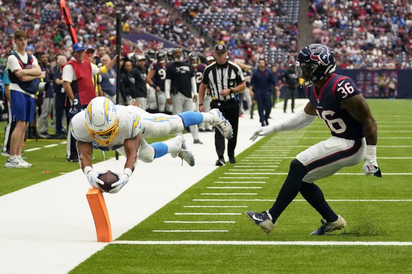 Los Angeles Chargers running back Austin Ekeler (30) dives for a touchdown past Houston Texans safety Jonathan Owens (36) during the second half of an NFL football game Sunday, Oct. 2, 2022, in Houston. (AP Photo/Eric Christian Smith)