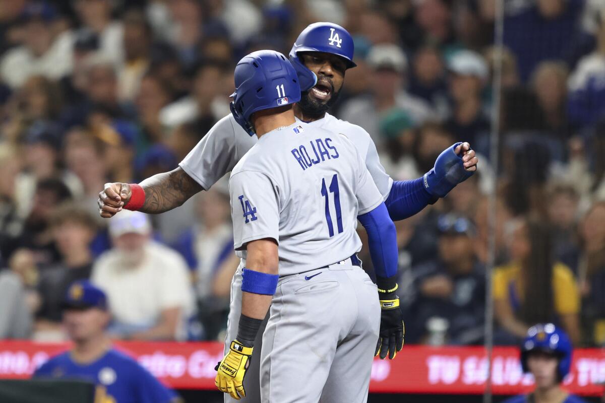Miguel Rojas celebrates with Jason Heyward after hitting a two-run home run for the Dodgers against the Mariners.