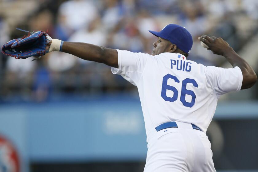 Dodgers right fielder Yasiel Puig fires a ball in after catching a fly ball in foul territory against the Brewers.