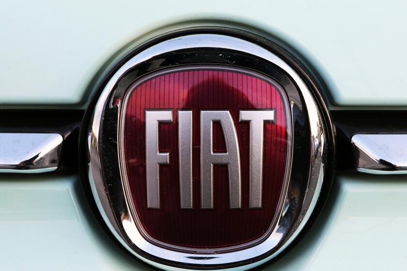 FILE - In this Oct. 31, 2019 file photo, a Fiat logo is pictured on a car in Bayonne, southwestern France. Fiat Chrysler Automobiles and PSA Peugeot announced Wednesday, Dec. 18, 2019, that their boards signed a binding deal to merge the two automakers, creating the world’s fourth-largest auto company. (AP Photo/Bob Edme, File)