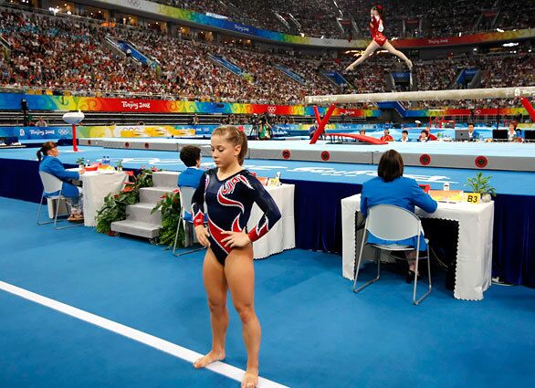 U.S. gymnast Shawn Johnson prepares for her balance beam routine as China's Li Shanshan performs during the finals at Beijing's National Indoor Stadium. Shanshan fell during her routine; Johnson nailed hers for the gold medal.