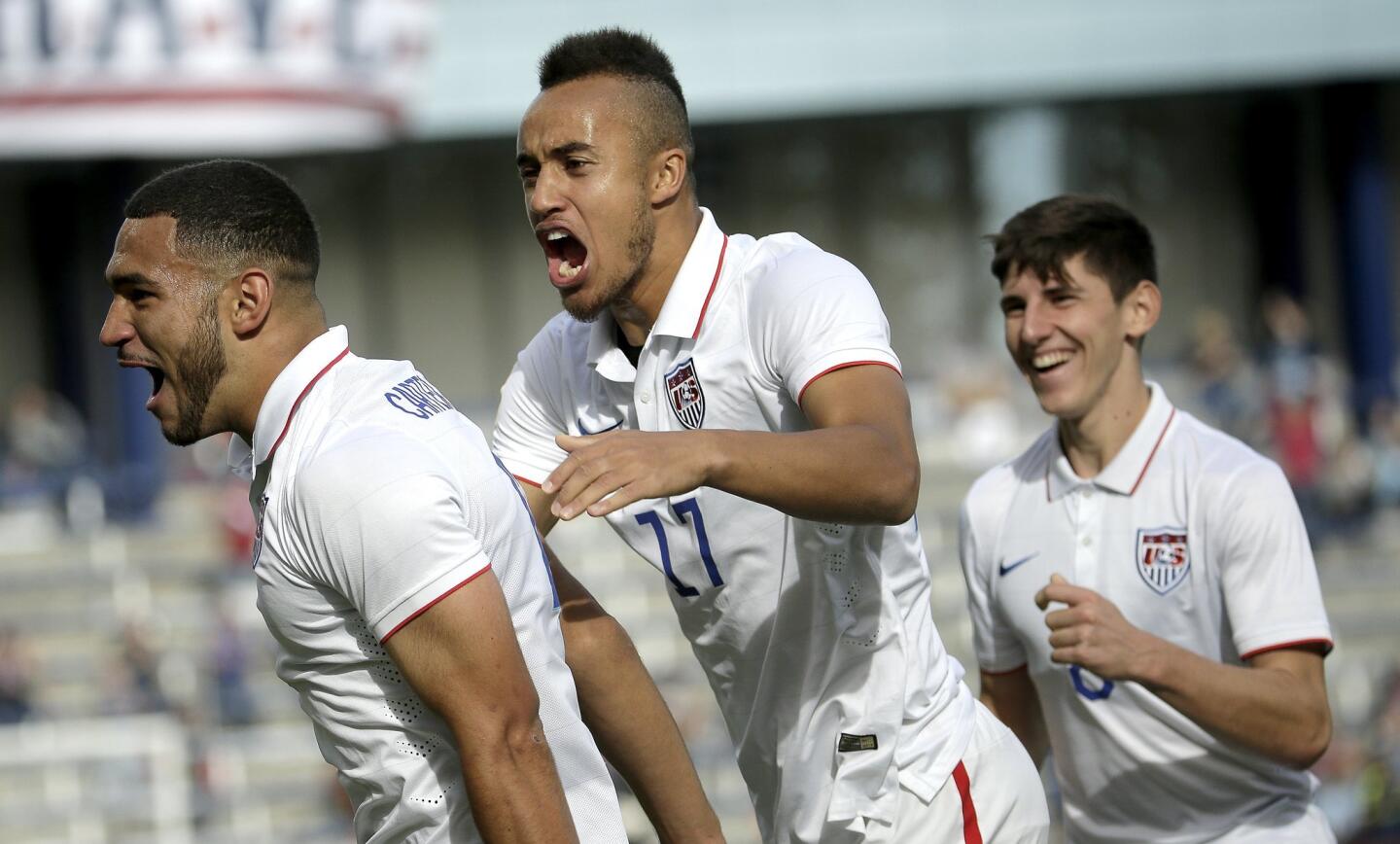 United States defender Cameron Carter-Vickers, left, celebrates with forward Jerome Kiesewetter (17) and midfielder Emerson Hyndman (8) after scoring a goal during the first half of a CONCACAF men's Olympic qualifying soccer match against Cuba, Saturday, Oct. 3, 2015, in Kansas City, Kan. (AP Photo/Charlie Riedel)