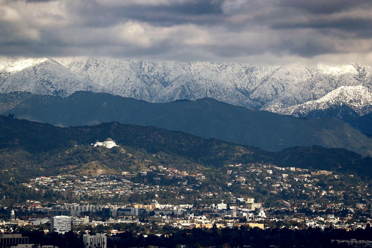 Clouds partially obscure mountains covered in snow north of Los Angeles on Sunday.