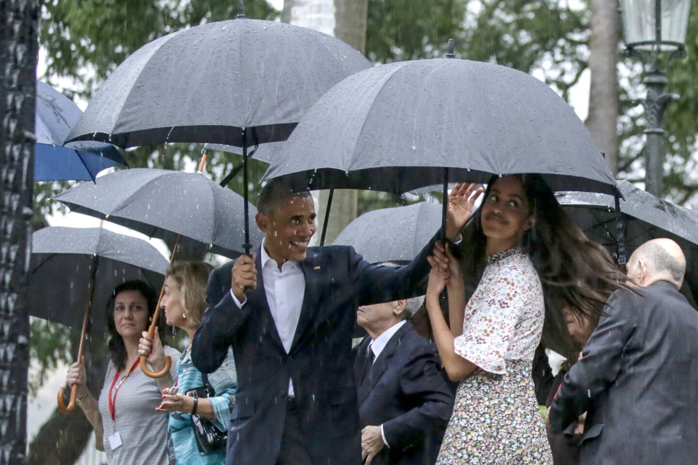 President Barack Obama, along with his daughter, waves to well wishers as he tours Old Havana with his family soon after touching down on Air Force One, becoming the first sitting President since Calvin Coolidge to visit Cuba.