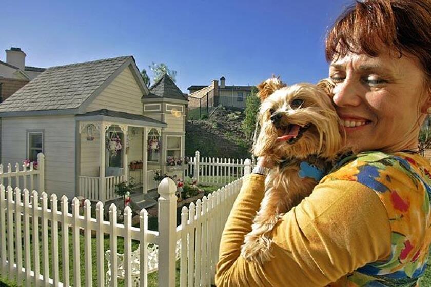 Tammy Kassis holds Coco Puff in front of her Victorian doggie mansion located in the Riverside County community of Winchester. Coco Puff shares the doggie estate with fellow Yorkshire terrier Chelsea and sassy Pomeranian Darla. Five years ago, when Kassis and her husband, Sam, were living in a Victorian home in Temecula, she decided the dogs needed their own place, so they had the fancy doghouse built. When the Kassises moved to Winchester this summer, they brought the 5,000-pound home with them.