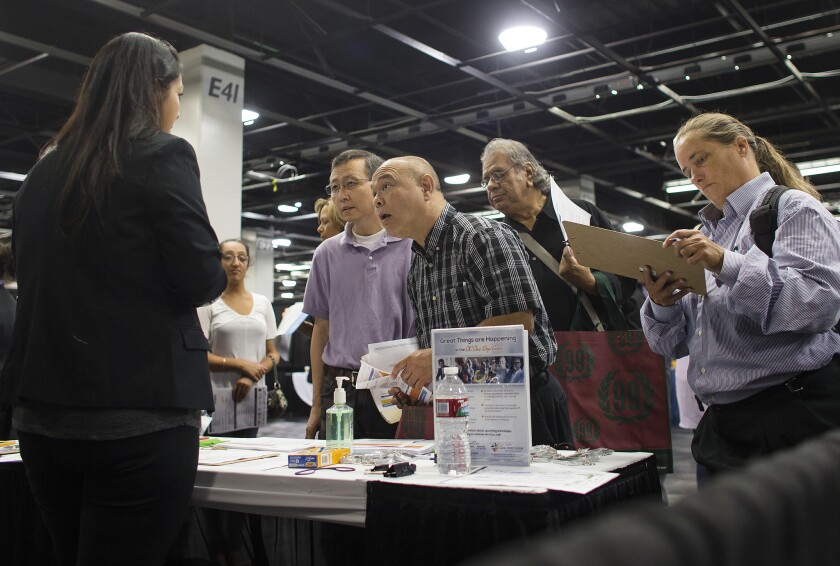 Stella Portillo, left, talks with job seekers at a job fair at the Anaheim Convention Center in June. California is growing jobs at one of the fastest rates in the nation, but experts worry that much of the growth is concentrated in lower-paying professions.