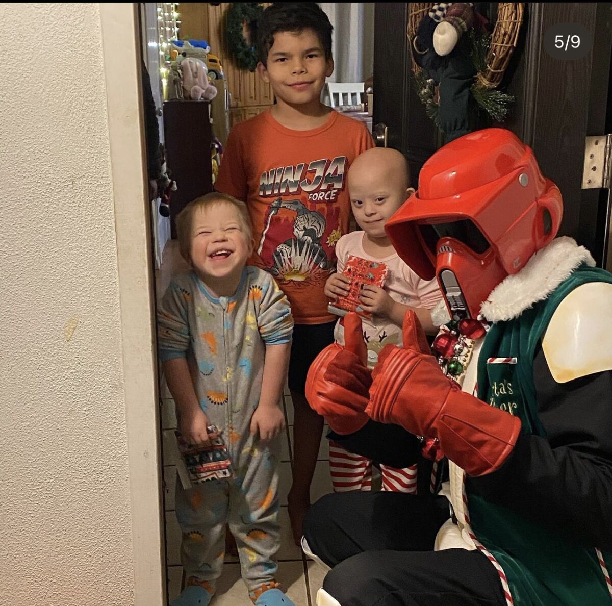 Yuri Williams gives thumbs up while dressed as a Stormtrooper and delivering gifts to children in 2020.