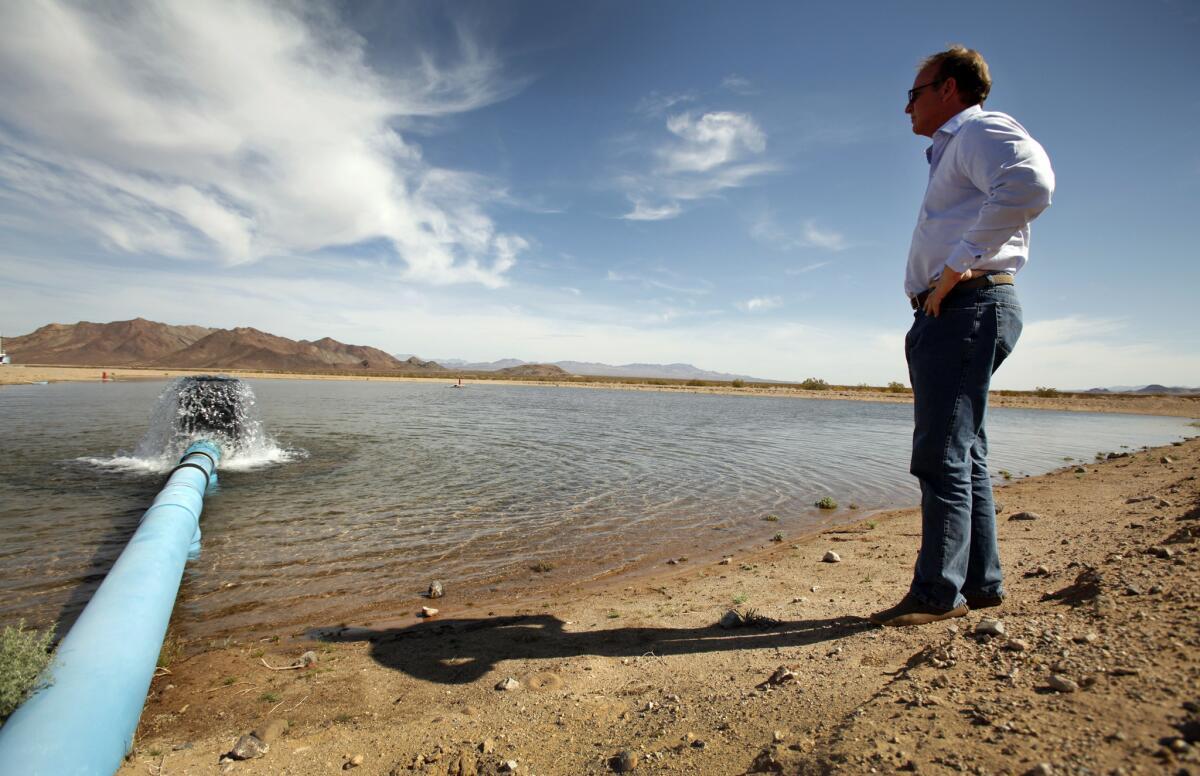 Scott Slater, president and general counsel of Cadiz Inc. watches as water pours out into a spreading basin on April 18, 2012.