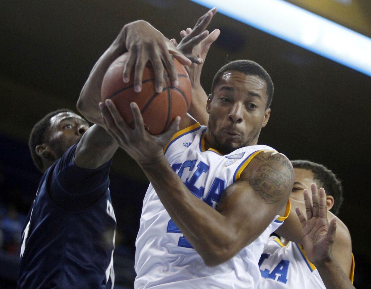 UCLA guard Norman Powell pulls down a rebound in front of Chattanooga guard Casey Jones, left, during the Bruins' blowout victory Sunday.