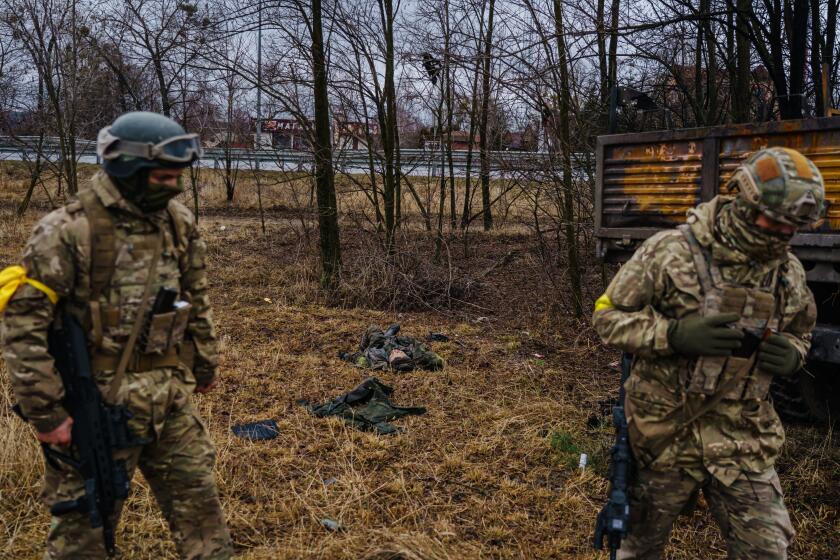 SYTNYAKY, UKRAINE -- MARCH 3, 2022: A dead Russian soldier is thrown on the ground, on the side of the road after a Russian vehicle was destroyed Ukrainian forces along the main road near Sytnyaky, Ukraine, Thursday, March 3, 2022. (MARCUS YAM / LOS ANGELES TIMES)