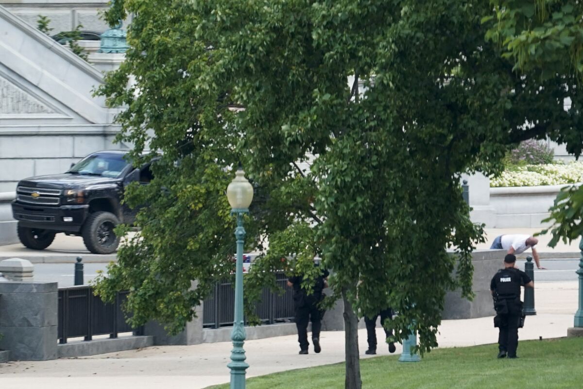 FILE - A man is apprehended after being in a pickup truck parked on the sidewalk in front of the Library of Congress' Thomas Jefferson Building, as seen from a window of the U.S. Capitol, Aug. 19, 2021, in Washington. A man who caused evacuations and an hourslong standoff with police on Capitol Hill when he claimed he had a bomb in his pickup truck outside the Library of Congress pleaded guilty on Friday, Jan. 27, 2023, to a charge of threatening to use an explosive. Floyd Ray Roseberry faces up to 10 years behind bars and is scheduled to be sentenced in June. (AP Photo/Alex Brandon, File)