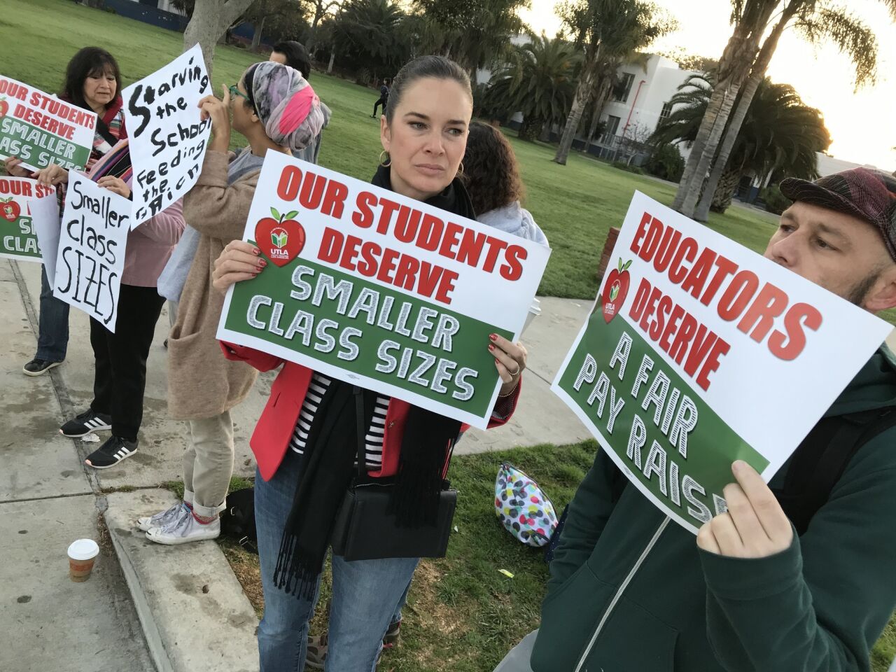 Anastasia Foster, center, and Timothy Hayes right and join supporters of LAUSD teachers for a rally in front of Venice High School.