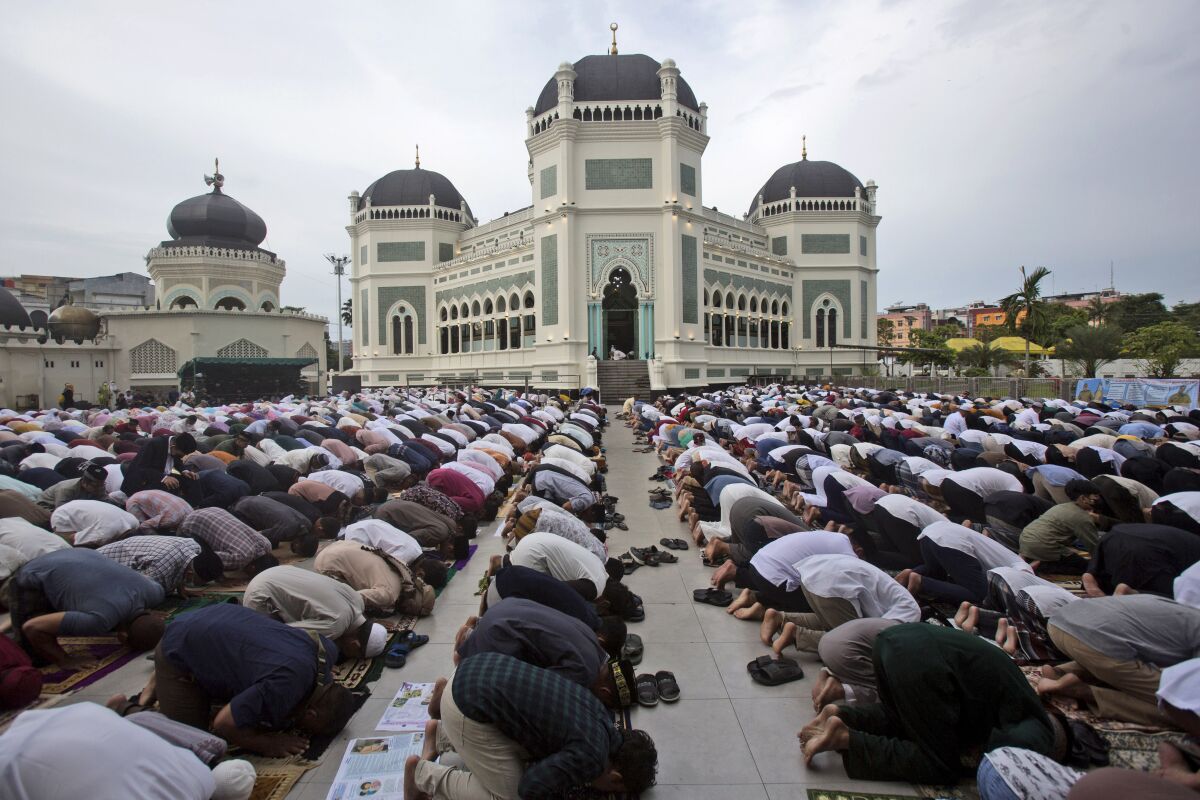 Indonesians perform a prayer marking the Eid al-Adha holiday at Al Mashun Great Mosque in Medan, Indonesia, Sunday, July 10, 2022. Muslims around the world are celebrating Eid al-Adha, the Festival of Sacrifice, by slaughtering sheep, goats, cows and camels and sharing the meat with the poor to commemorate the Quranic story of the Prophet Ibrahim's willingness to sacrifice his son Ismail as an act of obedience to God. (AP Photo/Binsar Bakkara)