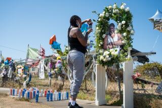 LOS ANGELES, CA - AUG. 28, 2021: Keishia Brunston takes a photo at a memorial for Dijon Kizzee Saturday, Aug. 28, 2021, where Kizzee was shot by L.A. County Sheriff's last year. Members of the Coalition for Community Control Over the Police joined the family of Dijon Kizzee for a march to the L.A. County Sheriff's Department's South L.A. station to mark one year since his shooting by deputies. (Michael Owen Baker / For The Times)