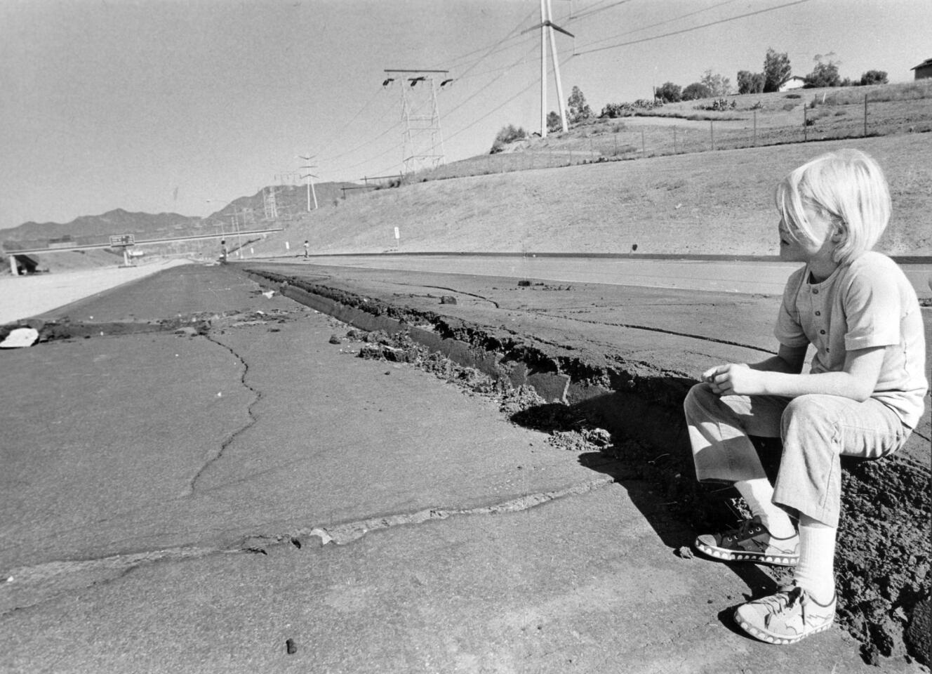 Jon Roennau, 9, rests on freeway breakage on Foothill Freeway caused by the February earthquake during field trip in Oct. 1971 by the Natural History Museum Alliance.