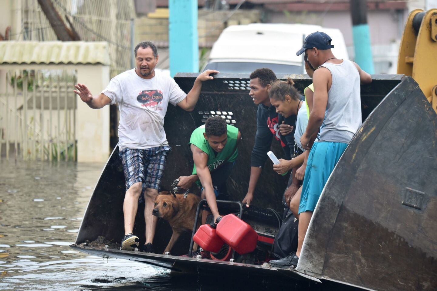 People are transported along a road flooded by Hurricane Maria in Juana Matos, Puerto Rico.