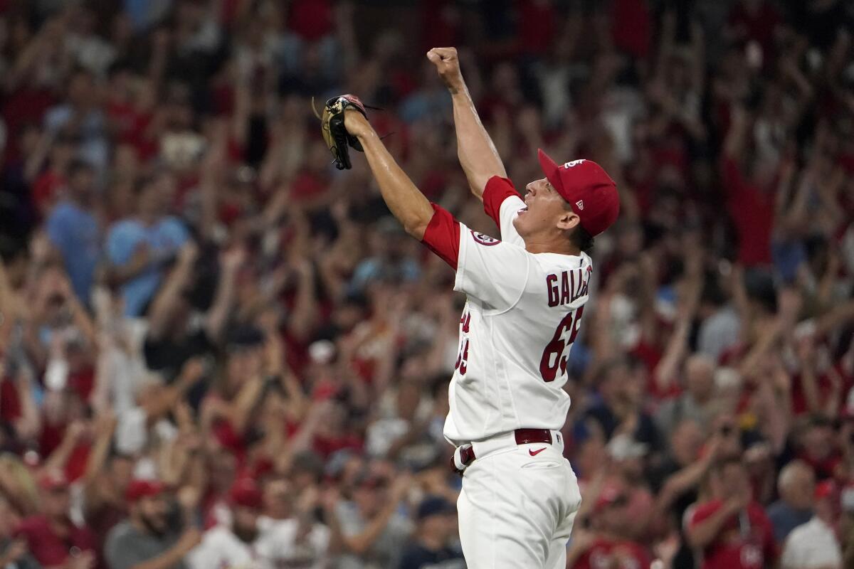 St. Louis Cardinals relief pitcher Giovanny Gallegos raises his arms in celebration.