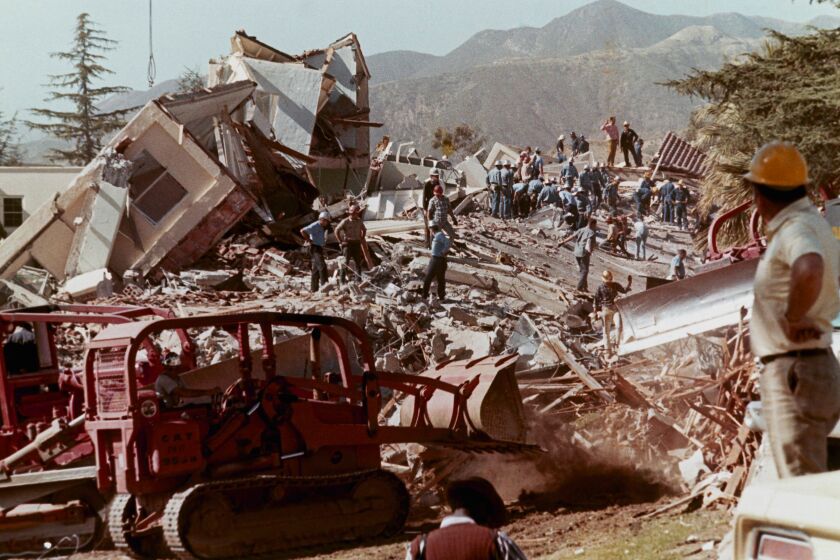 Workmen clear debris and rubble from collapsed buildings at the Veteran's Hospital in Sylmar, Calif., after a massive earthquake hit the area, Feb. 9, 1971. (AP Photo)